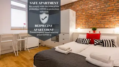 a bedroom with a brick wall and a bed with pillows at Old Town Topolowa 48 in Kraków