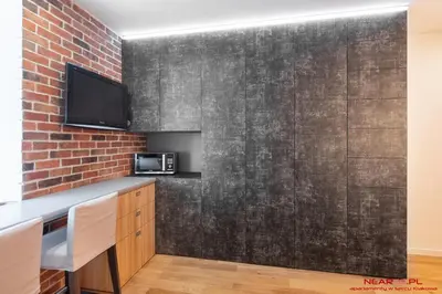 a kitchen with a brick wall and a tv at Old Town Topolowa 48 in Kraków