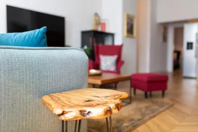 a living room with a chair with a wooden table at TCF Home - Big Apartment with Free Garage in Kraków