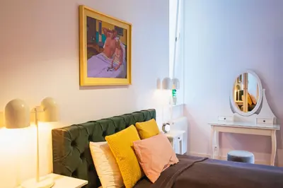 a living room with a green couch and a mirror at TCF Home - Big Apartment with Free Garage in Kraków