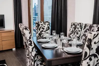 a dining room table with glasses and plates on it at CracWoW VIP Apartment in Kraków