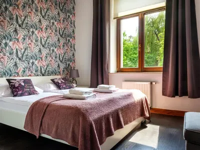 a bedroom with a bed with a floral wallpaper at CracWoW VIP Apartment in Kraków