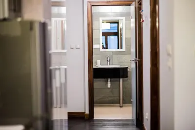 a bathroom with a sink and a mirror at CracWoW VIP Apartment in Kraków