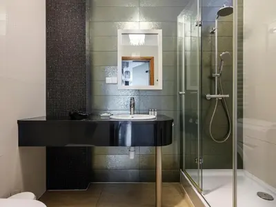 a bathroom with a sink and a shower at CracWoW VIP Apartment in Kraków