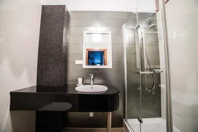 a bathroom with a sink and a shower at CracWoW VIP Apartment in Kraków