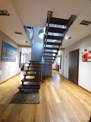 a staircase in a room with wooden floors and a hallway at Villa ENERGY in Zator