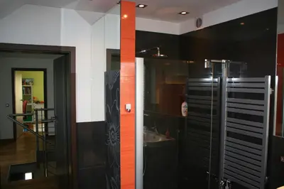 a bathroom with a glass shower with an orange stripe at Villa ENERGY in Zator
