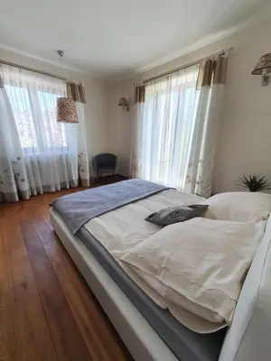 a large bed in a bedroom with windows at Villa ENERGY in Zator