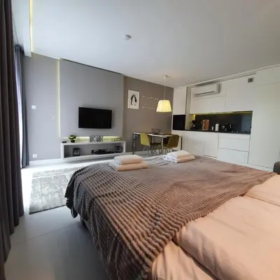 a bedroom with a large bed with a tv on the wall at Studio Łazarza 13 in Kraków
