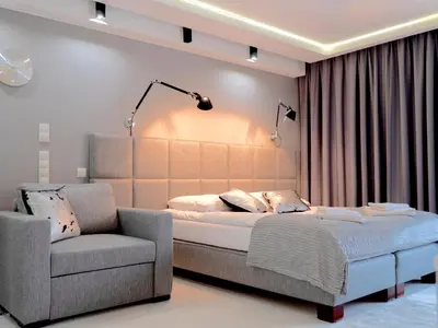 a bedroom with a large bed and a chair at Studio Łazarza 13 in Kraków
