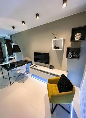 a living room with a yellow chair and a desk at Studio Łazarza 13 in Kraków