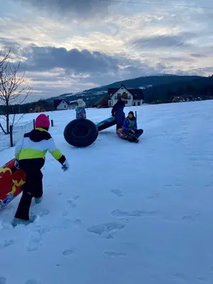 a group of people playing in the snow at Agroturystyka Pod Modrzewiem - Babia Góra in Zubrzyca Górna