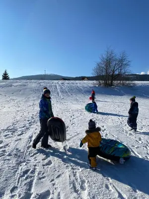 a group of people standing in the snow with snowboards at Agroturystyka Pod Modrzewiem - Babia Góra in Zubrzyca Górna