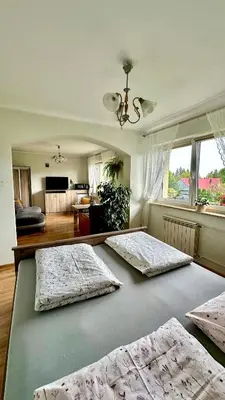 two beds in a room with a living room at Agroturystyka Pod Modrzewiem - Babia Góra in Zubrzyca Górna
