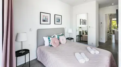 a bedroom with a large bed with two pillows on it at MY KRAKOW Apartments - Rakowicka in Kraków