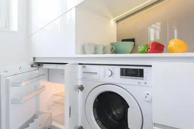 a white laundry room with a washing machine at MY KRAKOW Apartments - Rakowicka in Kraków