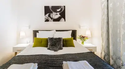 a bedroom with a large bed with green pillows at MY KRAKOW Apartments - Rakowicka in Kraków