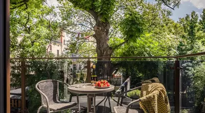 a patio with a table and chairs and a tree at MY KRAKOW Apartments - Rakowicka in Kraków