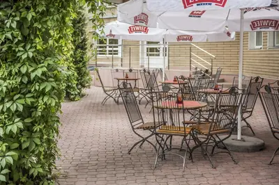 a group of tables and chairs with umbrellas at Hotel Justyna in Kraków