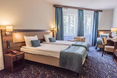 a hotel room with a large bed and a desk at Hotel Justyna in Kraków