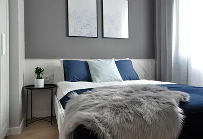 a bedroom with a blue and white bed with a furry blanket at NavyBlue apartment Cracow free parking TV in Kraków
