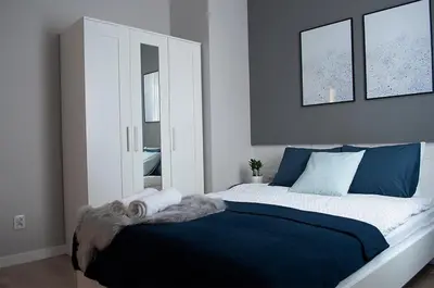 a bedroom with a large bed with two mirrors at NavyBlue apartment Cracow free parking TV in Kraków
