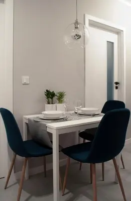 a dining room with a white table and blue chairs at NavyBlue apartment Cracow free parking TV in Kraków