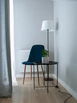 a green chair sitting next to a table with a lamp at NavyBlue apartment Cracow free parking TV in Kraków