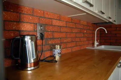 a coffeemaker on a kitchen counter with a brick wall at Friedleina 7 Kamienica Prezydencka in Kraków