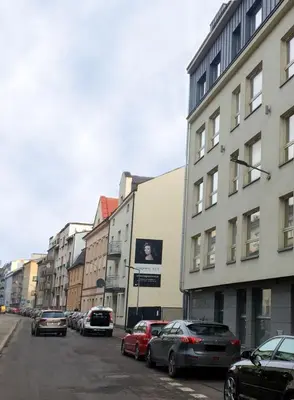 a city street with cars parked in front of buildings at Friedleina 7 Kamienica Prezydencka in Kraków