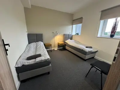 a room with two beds and a chair in it at PrzyStań S7 in Smroków