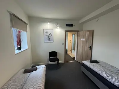 a room with two beds and a chair in it at PrzyStań S7 in Smroków