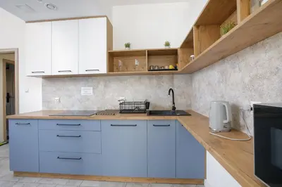 a kitchen with white cabinets and a counter top at PrzyStań S7 in Smroków