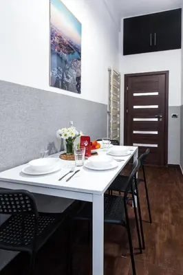 a white table in a kitchen with black chairs at Friendhouse Apartments Starovislna in Kraków