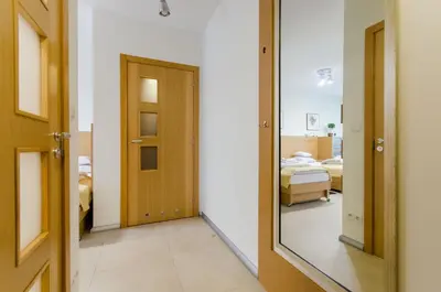 a hallway with a mirror and a bedroom at Family Apartments - Private Parking in Kraków