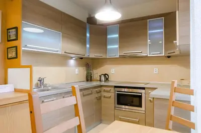 a kitchen with wooden cabinets and stainless steel appliances at Family Apartments - Private Parking in Kraków