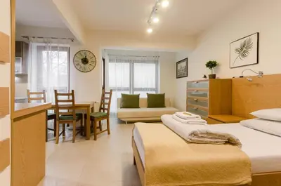 a bedroom with two beds and a dining room at Family Apartments - Private Parking in Kraków