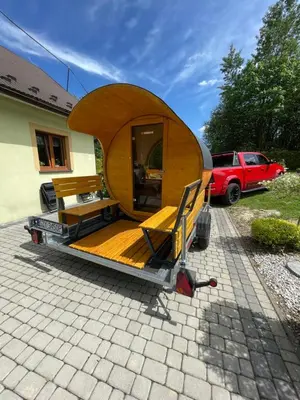 a wooden house on a trailer in a driveway at Agroturystyka 