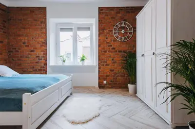 a bedroom with a bed and a brick wall at BRAND NEW ! Lovely Apartment in the fabulous location OLD TOWN JEWISH TOWN WAWEL CASTLE in Kraków