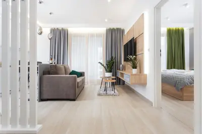 a bedroom and a living room with a bed and a couch at City of the Kings - Inca Apartment in Kraków