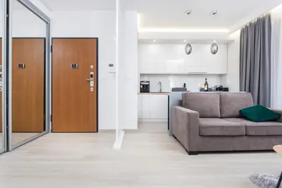 a living room with a couch and a kitchen at City of the Kings - Inca Apartment in Kraków