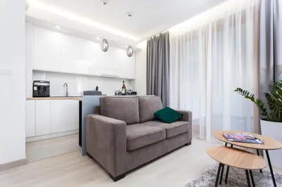 a living room with a couch and a kitchen at City of the Kings - Inca Apartment in Kraków