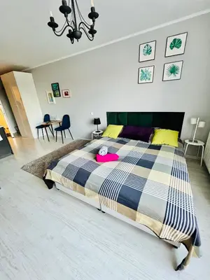 a bedroom with a large bed with a pink hat on it at Charming studio Center of Krakow in Kraków