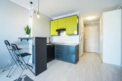 a kitchen with yellow cabinets and a counter at Charming studio Center of Krakow in Kraków