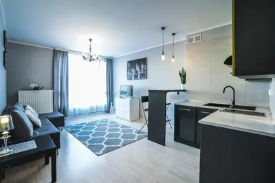 a kitchen and living room with a couch and a table at Charming studio Center of Krakow in Kraków