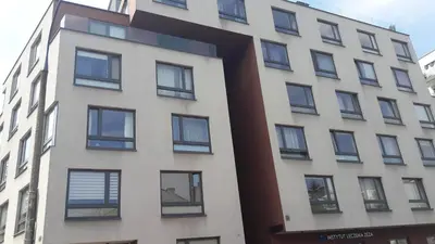 a tall white building with black windows at Charming studio Center of Krakow in Kraków