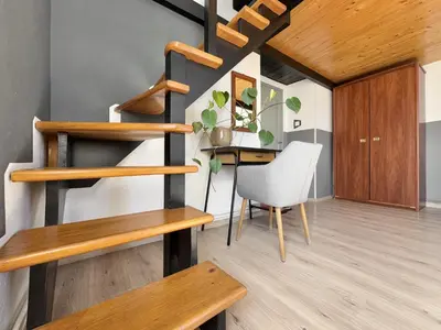 a staircase in a room with a table and a chair at GREEN APARTMENTS #Kazimierz, building B in Kraków