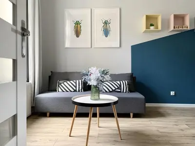 a living room with a couch and a table with flowers at GREEN APARTMENTS #Kazimierz, building B in Kraków