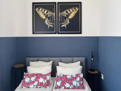 a bedroom with two beds with butterflies on the wall at GREEN APARTMENTS #Kazimierz, building B in Kraków