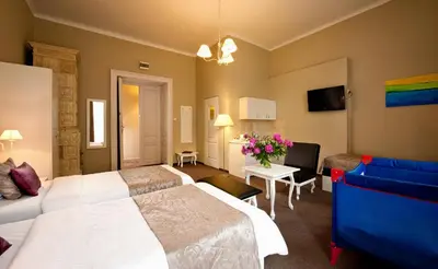 a hotel room with two beds and a tv at Leone Aparthotel in Kraków
